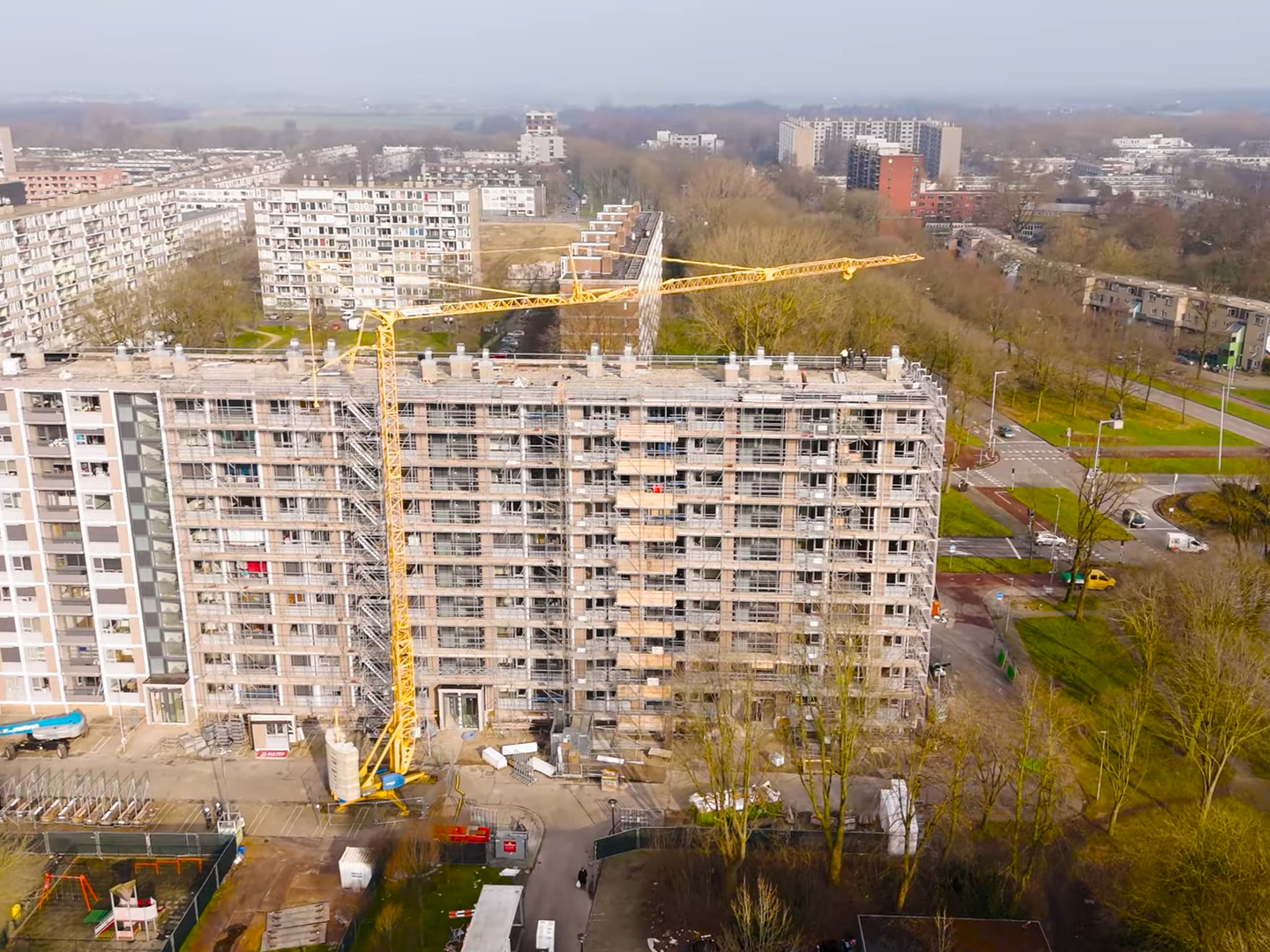 Verhuurde bouwkraan van Bulten Bouwkranen bij een flatgebouw in Utrecht waar kozijnen worden vervangen.