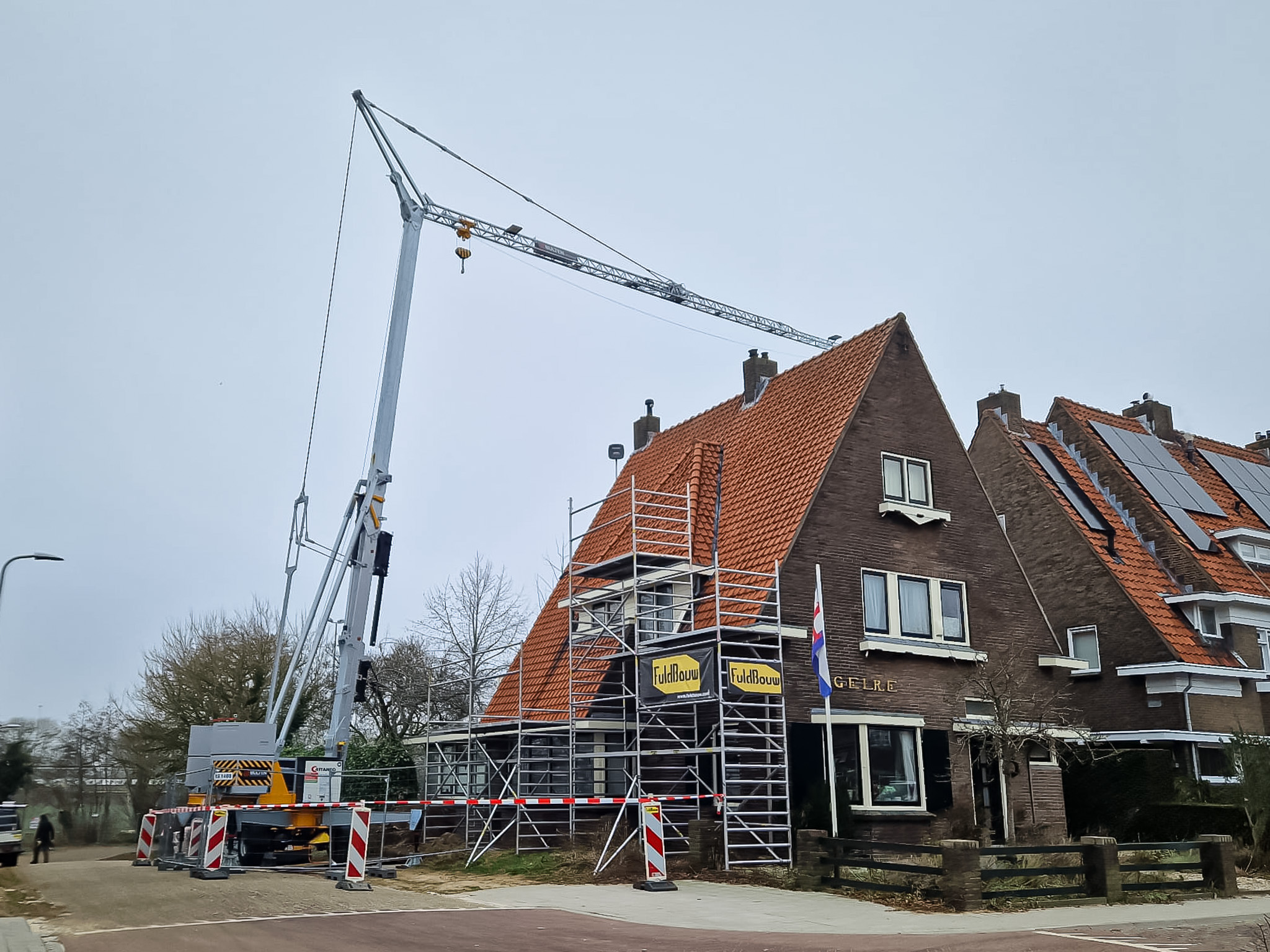 Verhuurde bouwkraan van Bulten Bouwkranen in Zutphen voor renovatie van het dak van een woonhuis.